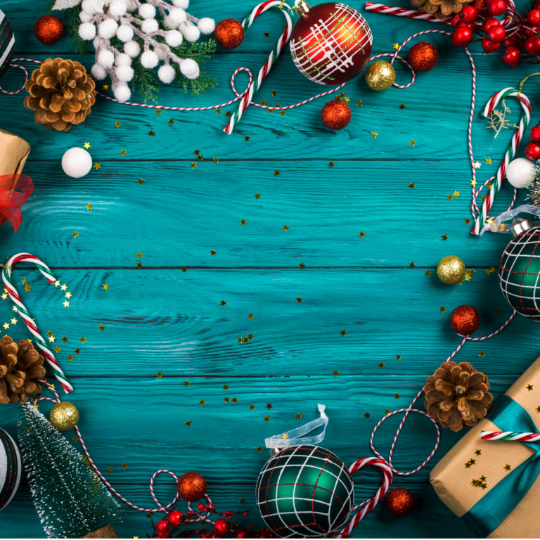 Christmas ornaments, beads, crafts type things, on the rim of a blue table.
