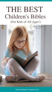 A girl sitting criss-cross applesauce holding a book in her lap